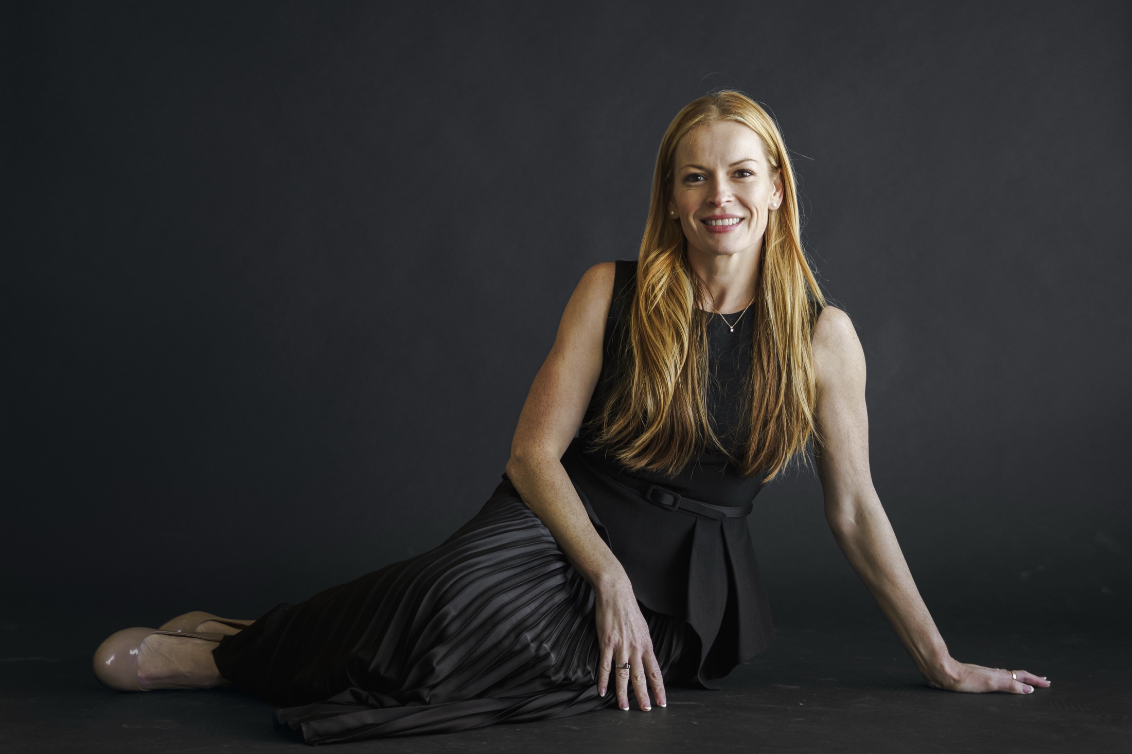 Steph Lombardo, real estate investor and AI systems builder, in a dark studio portrait